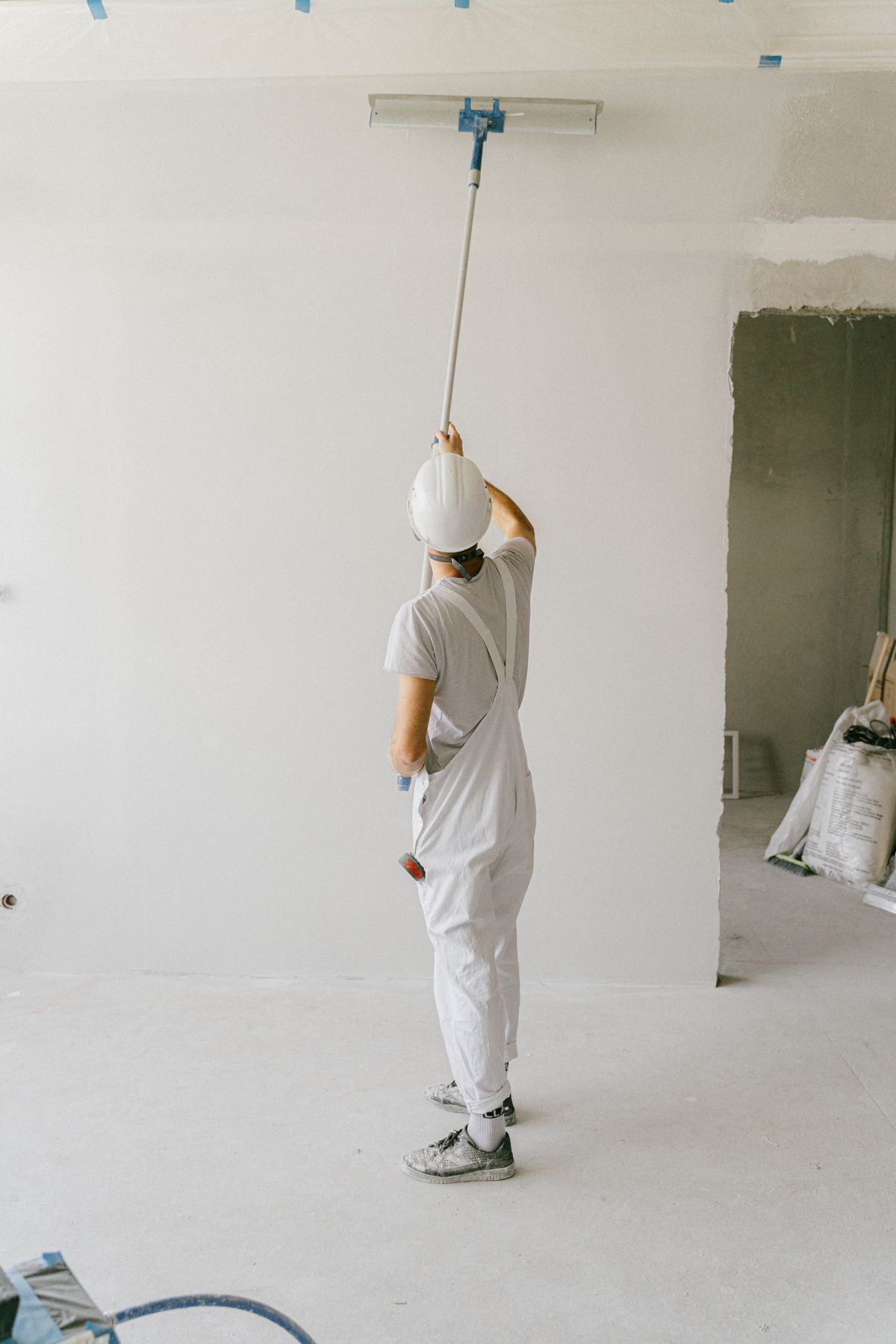 Peintre appliquant une finition sur un mur intérieur